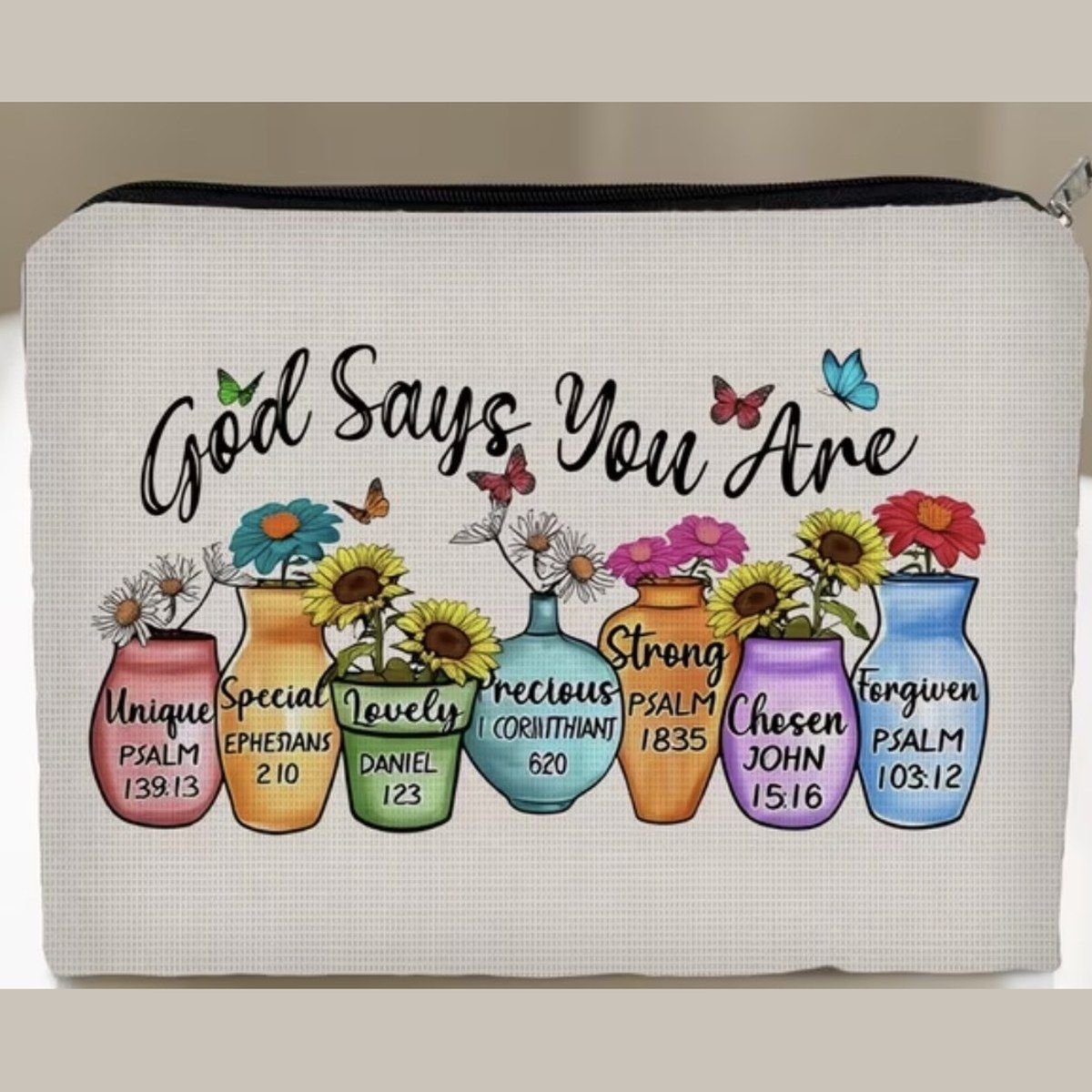 Zip pouch printed with God Says You Are and rows of flower pots naming verses about identity