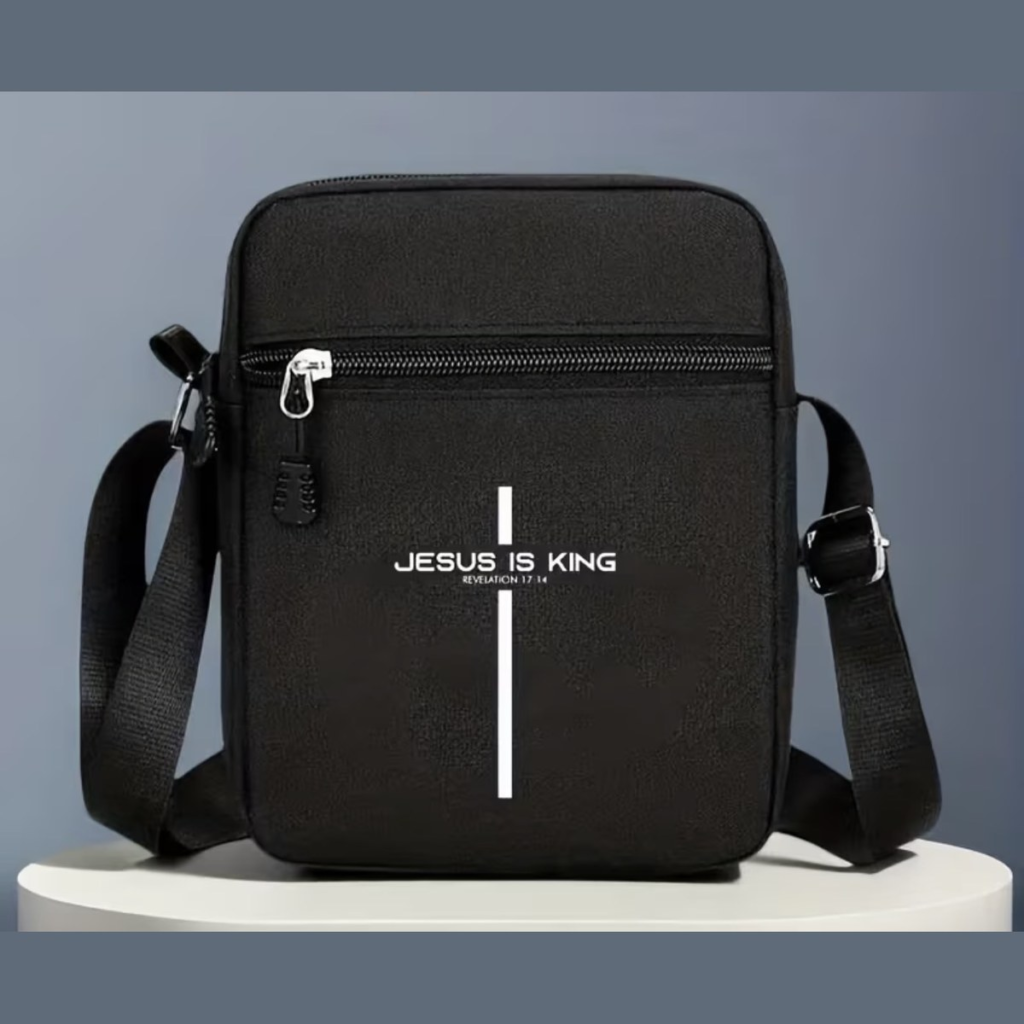 Black crossbody messenger bag printed with a white cross and the words Jesus Is King, Revelation 17:14